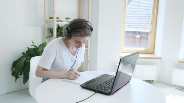 Jeune femme parle au tuteur, regarde ordinateur portable, écrit des notes. éducation en ligne — Video
