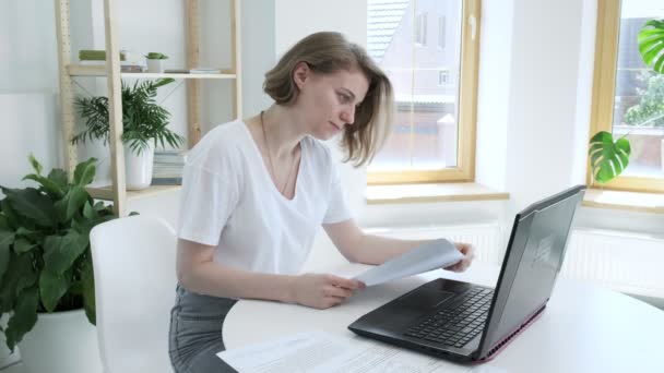 Fata verifică documente, găsește eroare, aruncă furios hârtie în laptop — Videoclip de stoc