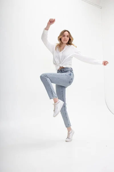 Lächelndes kaukasisches Mädchen in Hemd, Jeans, isoliert auf weißem Hintergrund springend — Stockfoto