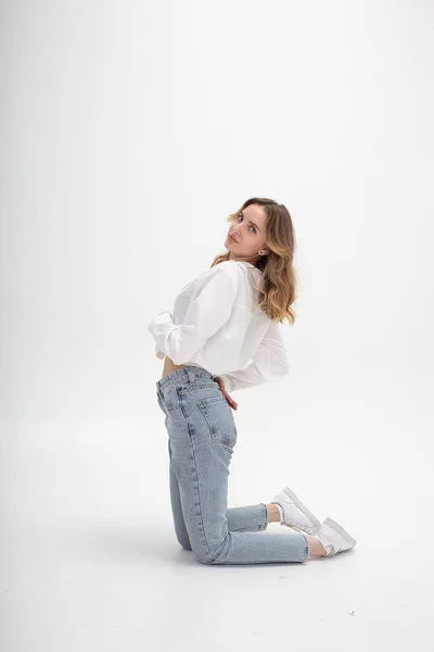 Joven chica caucásica en camisa, jeans, aislado sobre fondo blanco posando — Foto de Stock