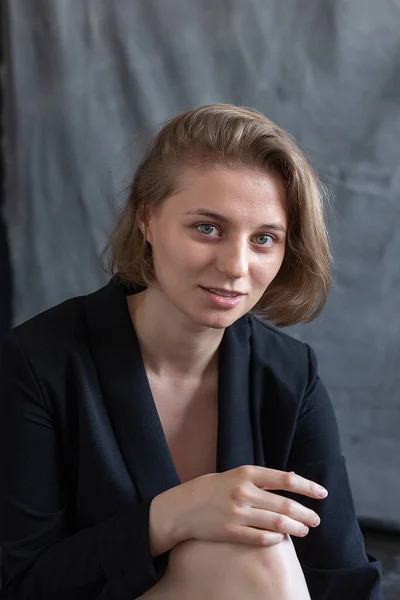 Portrait of young caucasian woman with short hair posing in black suit jacket — Stock Photo, Image