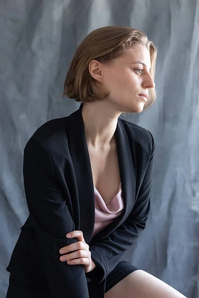 Portrait of young caucasian woman with short hair posing in black suit jacket — Stock Photo, Image