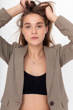 Beyaz arka planda siyah bluzlu ve takım elbiseli genç beyaz kadın.