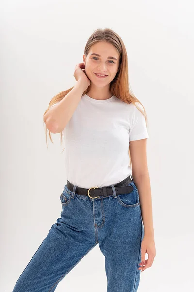 Jonge Kaukasische vrouw in t-shirt en blauwe jeans geïsoleerd op witte achtergrond — Stockfoto