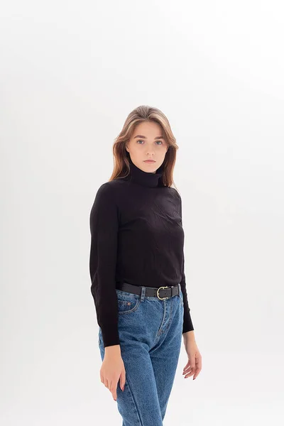 Young caucasian woman in turtleneck and blue jeans isolated on white background — Stock Photo, Image