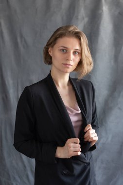 Siyah ceketli kısa saçlı, beyaz bir kadının portresi.