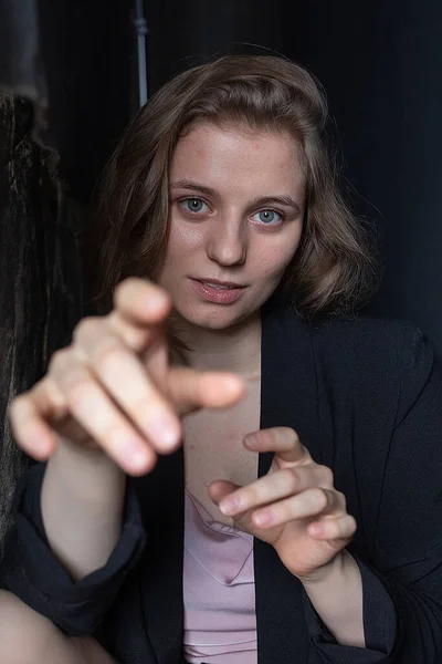 Portrait of pretty woman with short hair posing in jacket on black background — Stock Photo, Image