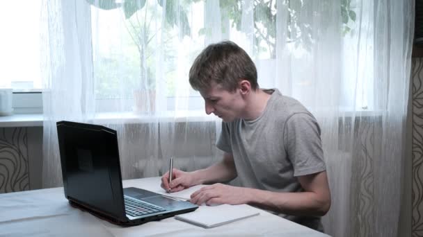 Joven habla con tutor, escribe notas. educación en línea en el ordenador portátil, trabajo remoto — Vídeos de Stock
