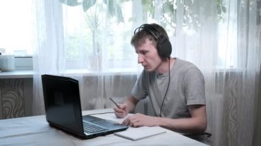 Genç adam hocayla konuşur, notlar yazar. Bilgisayarda çevrimiçi eğitim, uzak meslek