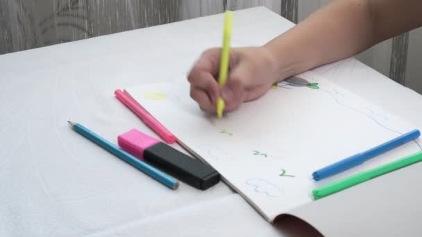 Primer plano de las niñas manos dibujo ilustración con plumas de fieltro en papel — Vídeos de Stock