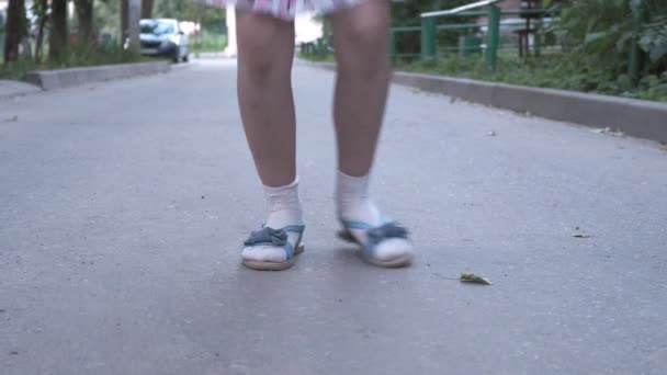 Nahaufnahme von kleinen Mädchen Beine, während sie springt Hopscotch spielen im Freien — Stockvideo