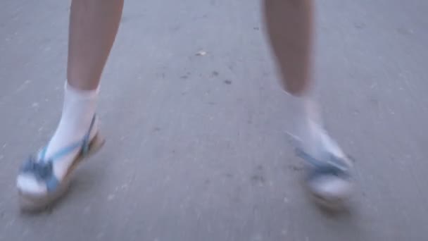 Closeup shot of little girls legs while she jumps playing hopscotch outdoors — Stock Video