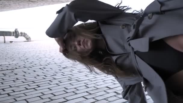 Aziatische mooi model dragen trench jas staan in de buurt van muren schot van onderen — Stockvideo