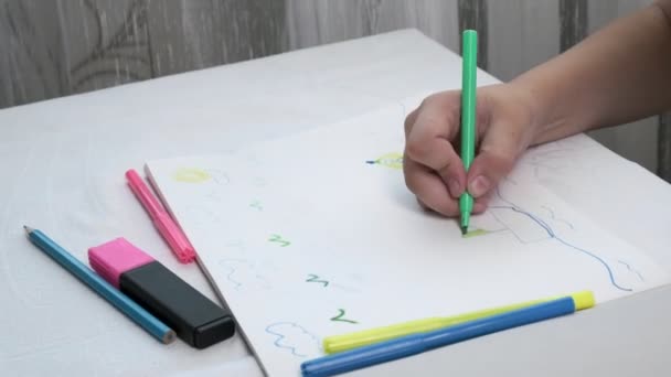 Fille en masque à gaz se trouve à table, dessine illustration avec des stylos en feutre dans l'album — Video