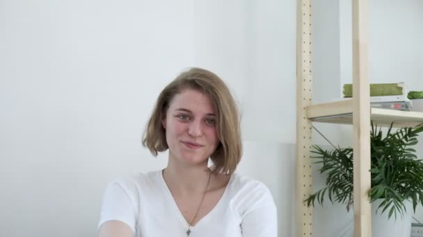 Ung leende kaukasiska kvinna hemma inser något allvarligt. förändrat humör — Stockvideo