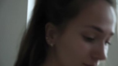Genç, formda, esmer kız oturma odasında esneme egzersizleri yapıyor.