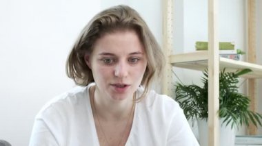 Üzgün beyaz tişörtlü beyaz kadın gözlerini kapar, iç çeker, nefes verir.