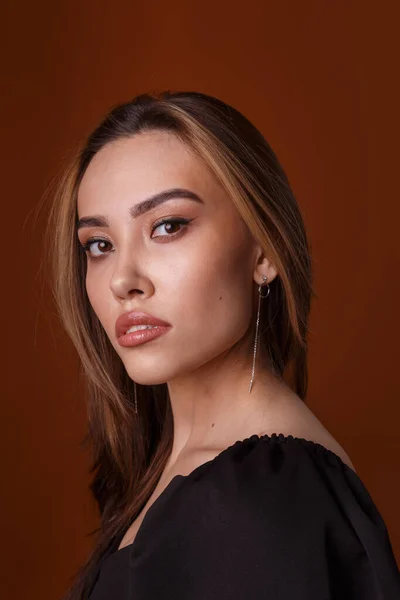 Elegante asiático jovem modelo vestindo preto vestido posando no laranja fundo — Fotografia de Stock
