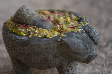 Çeşitli yiyecek, baharat, salsa ve guacamole ile öğütülmüş taş kase.