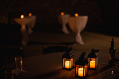 Masaların üzerinde mum ışığı olan gece fotoğrafı.