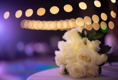 Düğün buketi çiçekleri, masasında beyaz güller Bulanık aydınlatma lambalarına karşı 