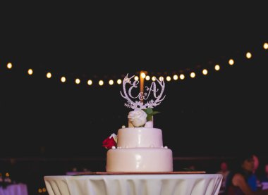 Düğün pastası masada, arka planda bulanık bokeh ışıkları 