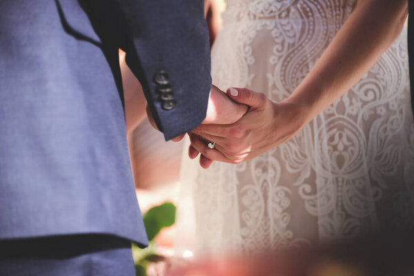 groom and bride in love holding hands on Wedding Ceremony, partial view