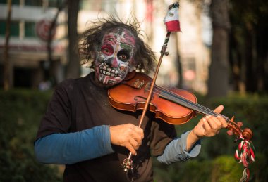 Meksika, Ekim 2017, Cadılar Bayramı kostümleri festivalde, adam keman çalıyor 