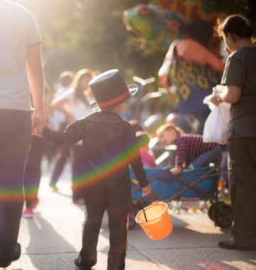 Meksika, Ekim 2017, Cadılar Bayramı kostümleri festivalde, çocuk şapkalı ve ailesi sokakta. 