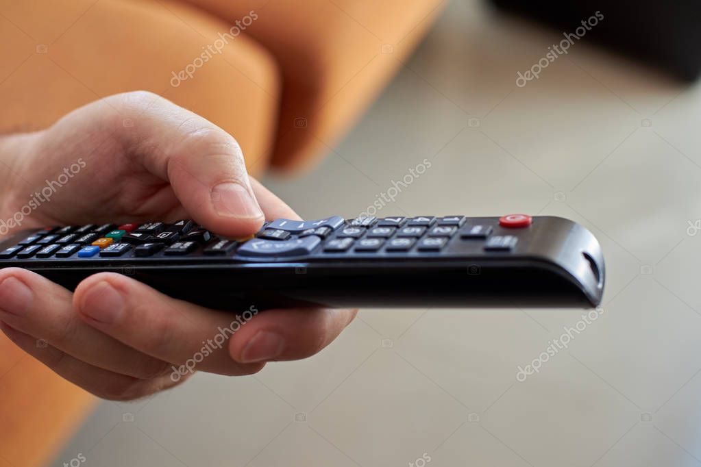 Mano que sostiene el control remoto que se utiliza. 2023