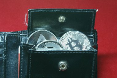 kadife kırmızı arka plan üzerinde siyah deri cüzdan kriptopara paraları