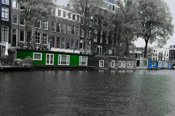 Woonboten in de nieuwe Prinsengracht Amsterdam in zwart-wit met blauw en groen verzadigd om in kleur te blijven — Stockfoto