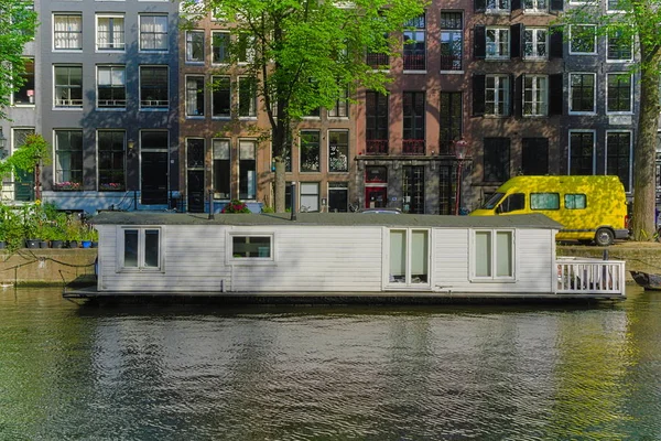 アムステルダムの運河に座っているハウスボート — ストック写真
