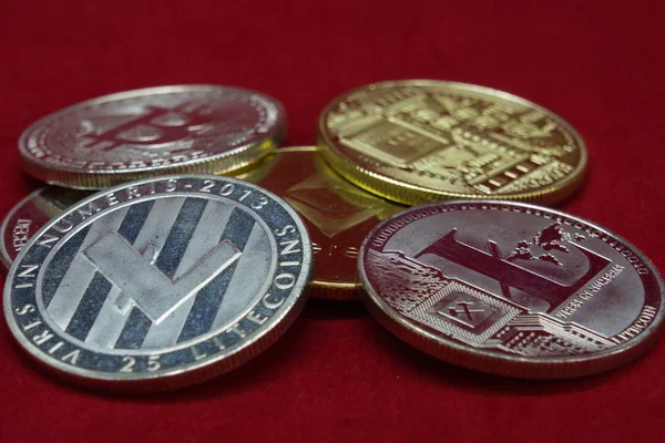 Una collezione di monete in argento e oro criptovaluta su sfondo di velluto rosso — Foto Stock