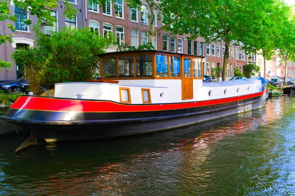 輸送ボートはアムステルダムの運河でハウスボートを使用しました — ストック写真