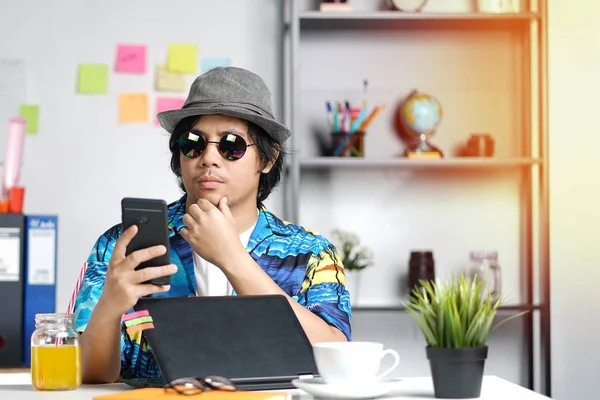 Stylish Young Professional Checking Smartphone While Working on Summer Vacation at Office