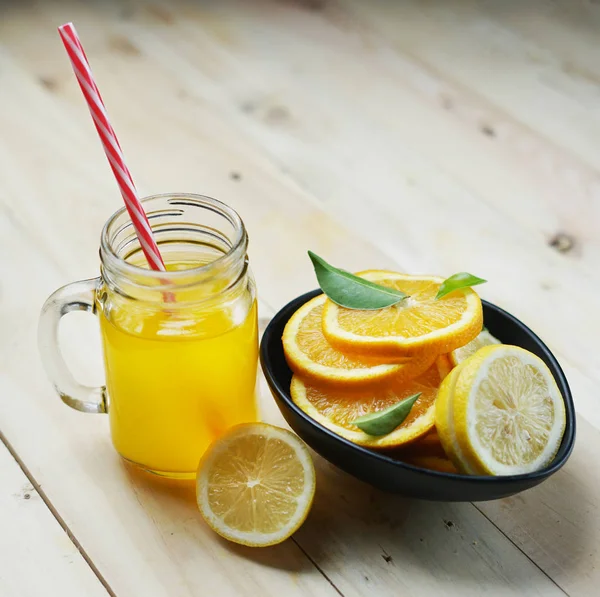 Orange Juice and Lemon Orange Leaves Citrus in a Black Bowl
