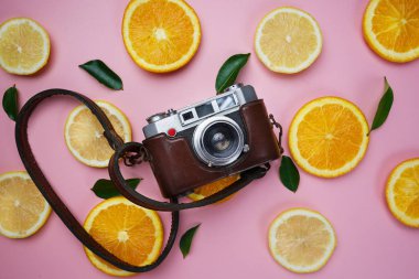 Portakal limon yaprakları narenciye desen üzerinde pembe bir arka plan en az düz Lay vintage fotoğraf makinesi