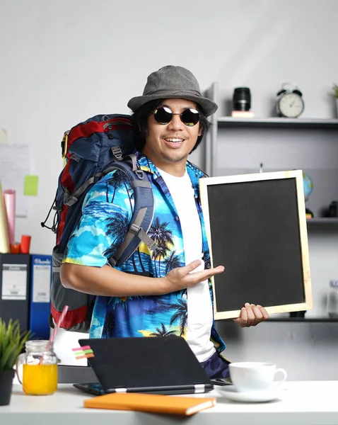 时尚的年轻人背着大背包 在办公室拿着黑板 — 图库照片