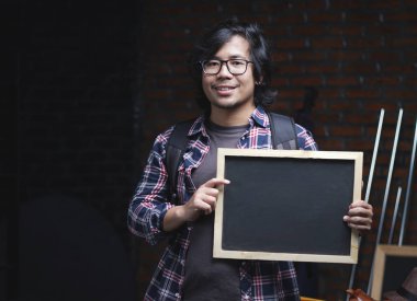 Blackboard ambar içinde tutarak Asya Koleji Öğrenci portresi. Kameraya gülümse 