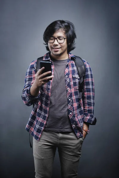 Asian College Student Sprawdzanie Telefonu Szarym Tle — Zdjęcie stockowe