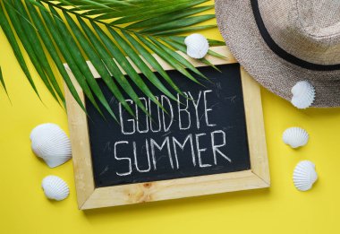 Güle güle yaz metin. Fedora şapka, palmiye yaprağı, deniz kabukları ve metin için yazı tahtası yer. Tatil tatil seyahat yat sarı arka plan