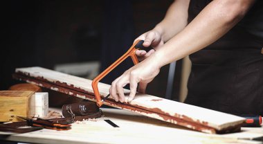 Marangoz ahşap atölyesinde çalışıyor. Ahşap plakalar testere ile kesme 