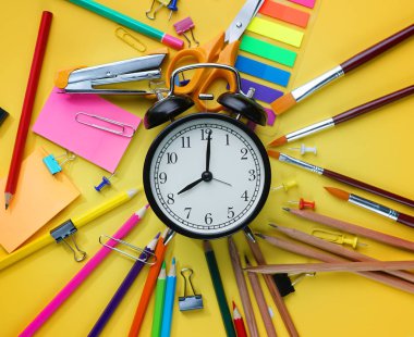 Çalar saat arasında okul sabit üst görünümden sarı zemin üzerine