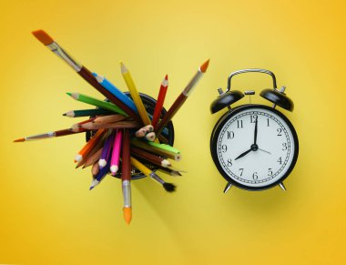 Çalar saat ve okul sabit sepet Top görünümünde sarı arka plan