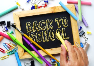 Okul metne geri. Tebeşir tutan el. Ahşap çerçeve Blackboard arasındaki okul kırtasiye