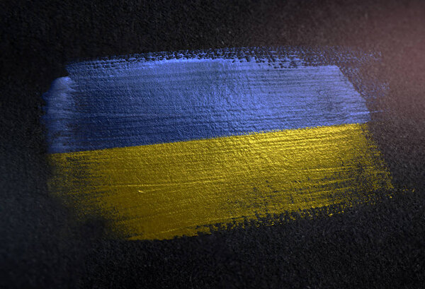 Флаг Украины из металлической кисти на гранжевой темной стене
