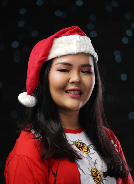 快乐亚洲女孩穿着圣诞老人服装圣诞暗辉光散景背景 — 图库照片