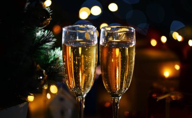 İki kadeh şampanya Noel ağacı yanında kapatın. Karanlık gece