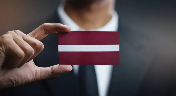 Uomo Affari Holding Card Latvia Bandiera — Foto Stock